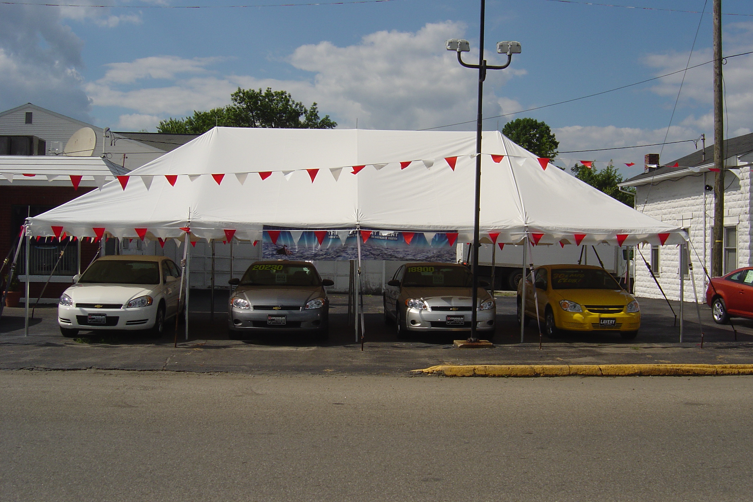White pole tent setup for car lot sale