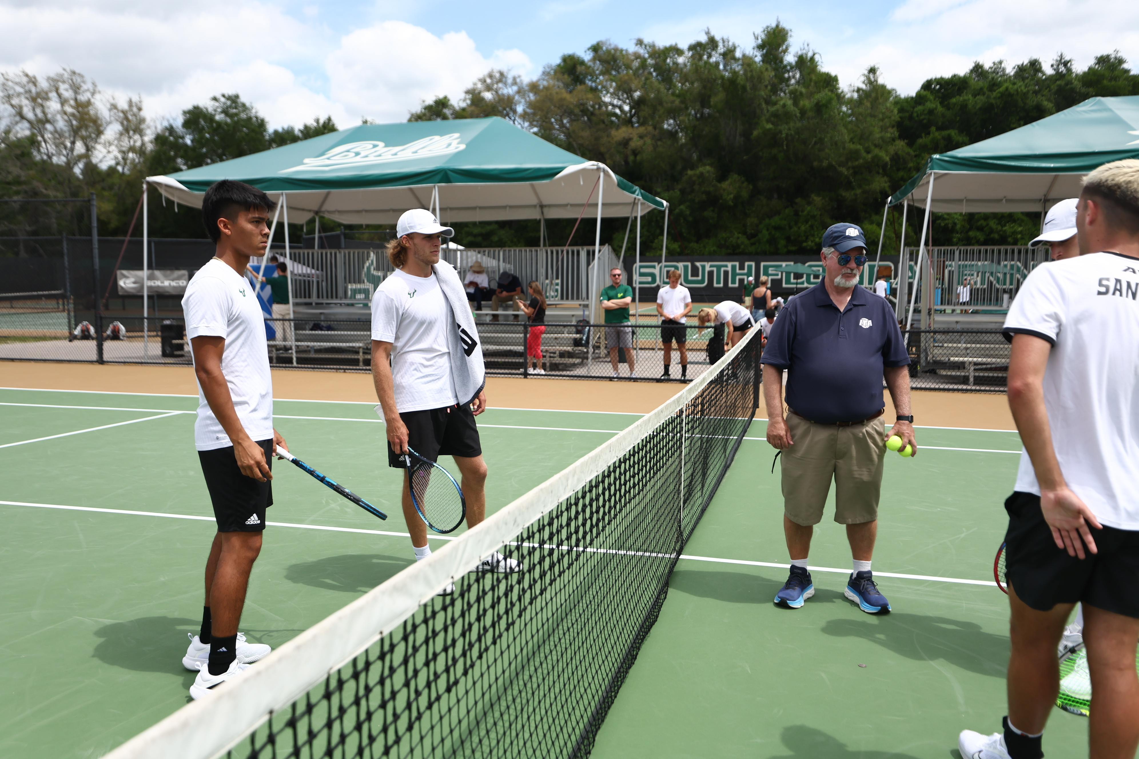 Sports team gathered under a bold, custom canopy at a tournament. 