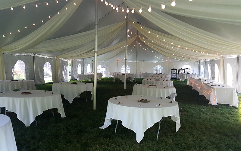 Guests enjoying an event under a party tent