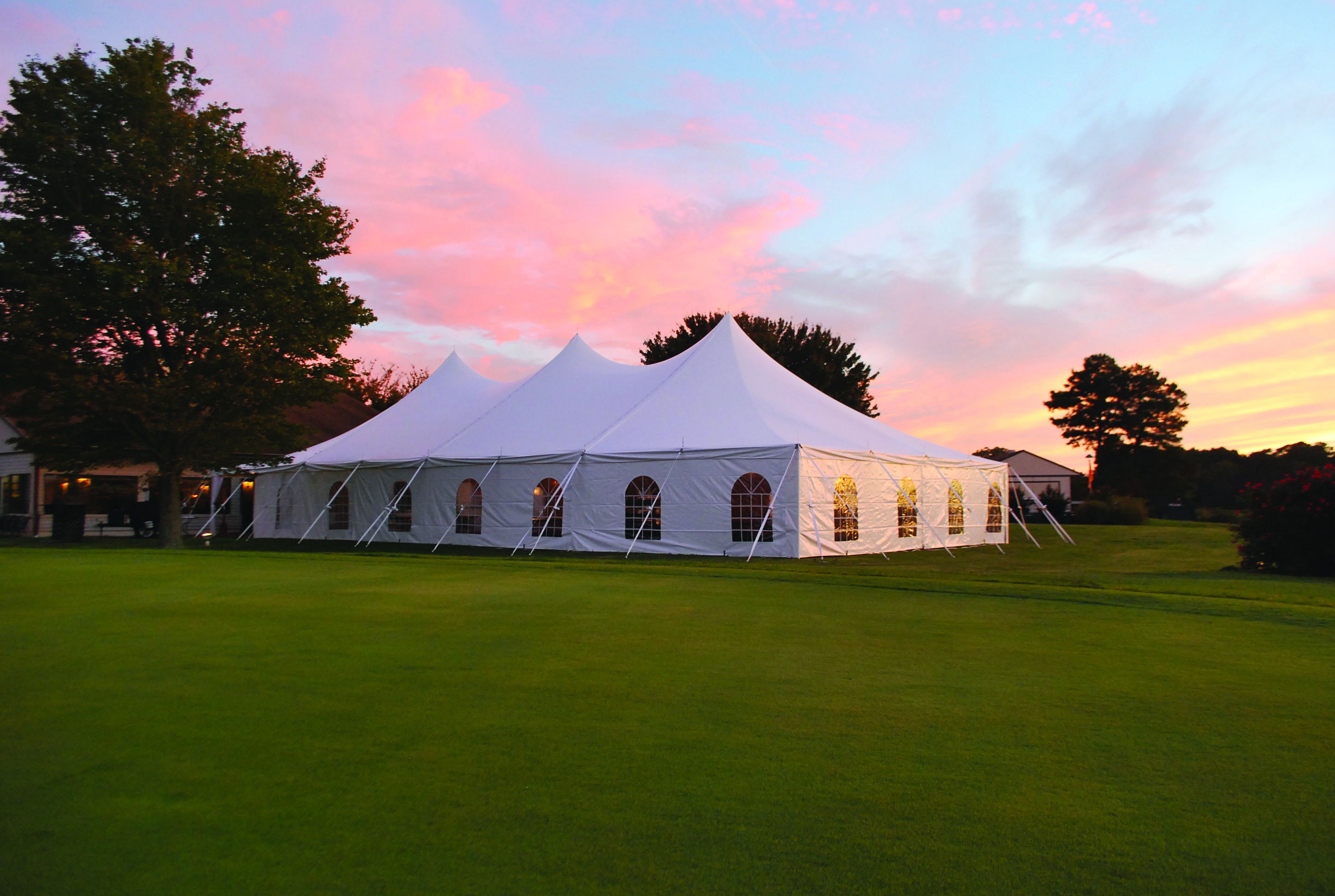 Elegant outdoor wedding reception under a luxury tent with sidewalls in 2025