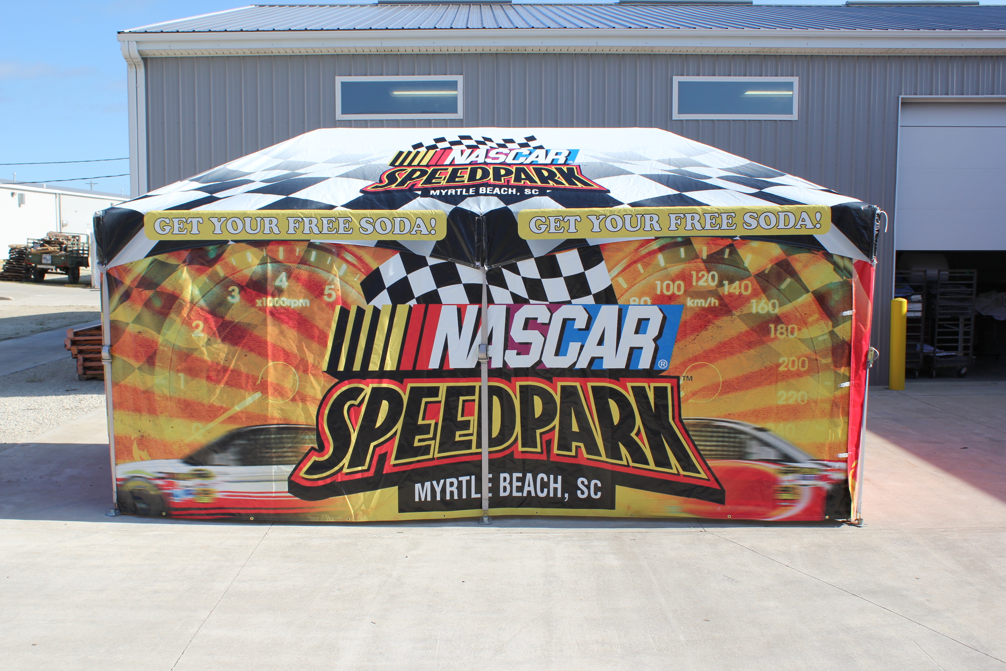 Branded tent sidewalls providing weather protection and visibility at an outdoor event.