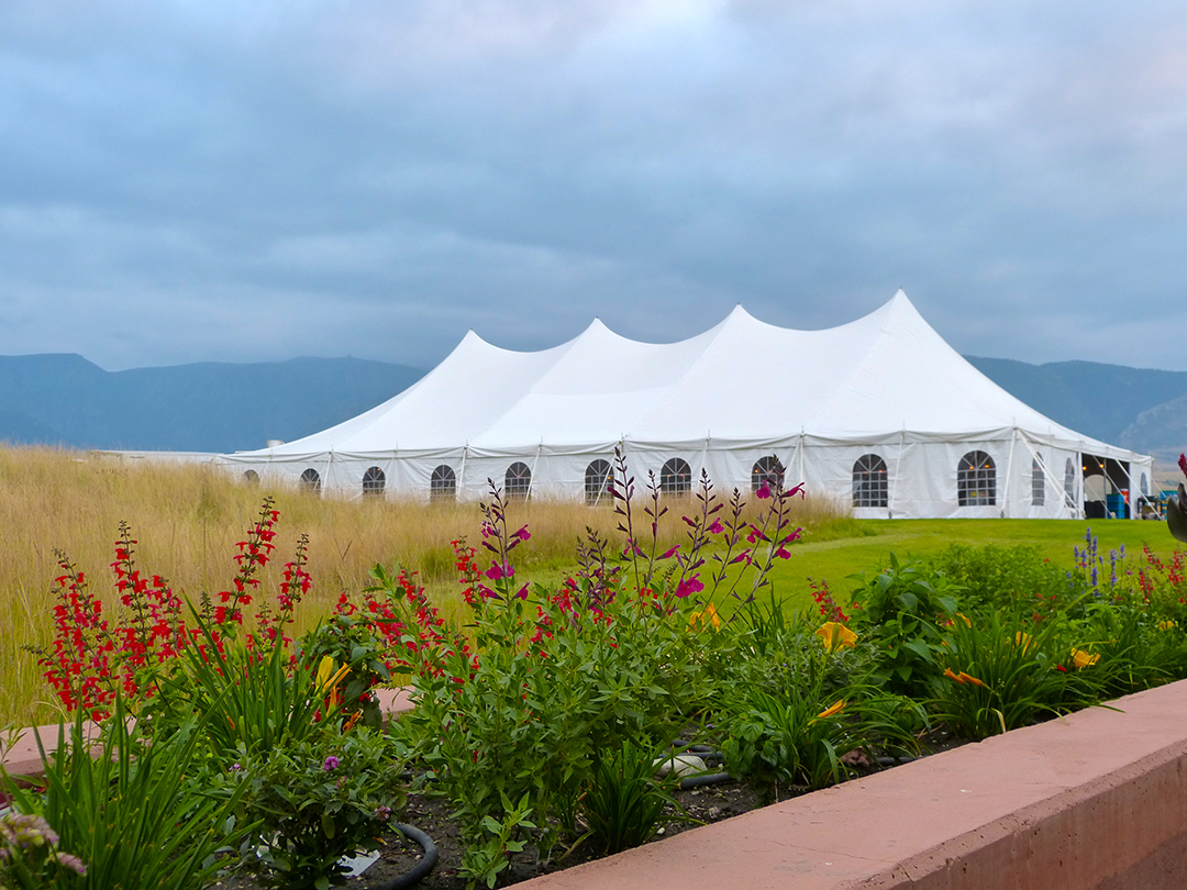 Large upscale white event tent setup with flowers